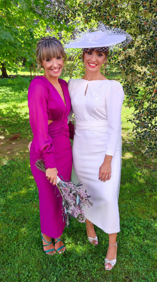 Novia y madrina con vestidos para boda en color blanco y fucsia y con detalles en las mangas